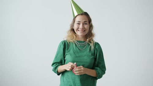 Woman Celebrates Wearing Party Hat and Noise Maker
