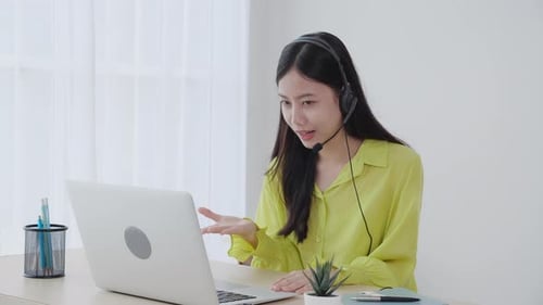 Woman Attending Video Conference Call at Desk