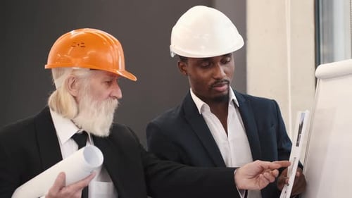 Architect and Engineer Looking at Scketch Blueprint at Office and Discussing Project