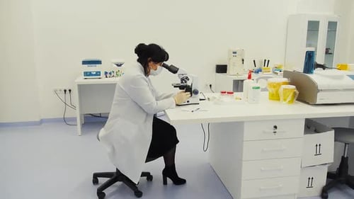 Woman Scientist Using Microscope in Modern Laboratory