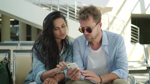Young Couple Looking at a Smartphone at Airport