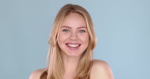 Potrait of Beautiful Blond Woman with Long Hair Posing in Studio on Blue Background