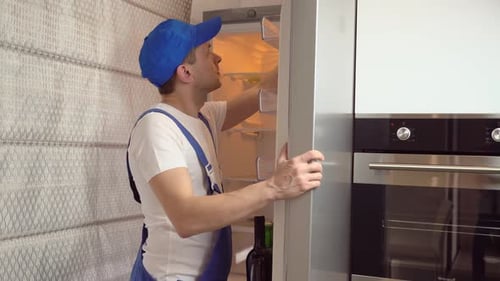 Refrigerator Repair by Service Man in Overalls