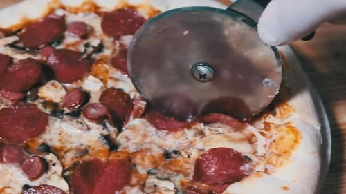 Cutting Delicious Pepperoni Pizza with Metal Pizza Cutter