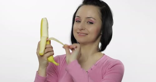 Woman Eats Banana in a Bright Studio