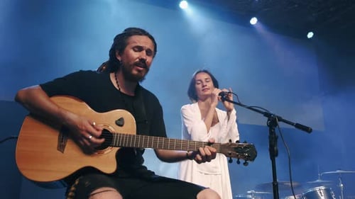 Musical Duo Performs Live on Stage with Guitar