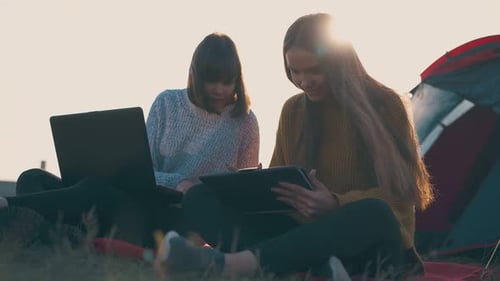 Women Friends Using Tablet Outdoors Near Tent