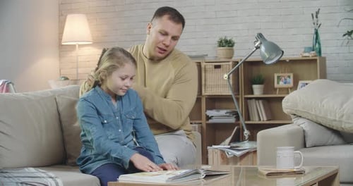 Man Brushes a Girl's Hair at Home