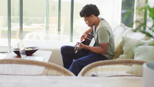 Young Adult Plays Guitar at Home