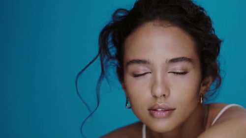 Woman Posing in Front of Blue Background