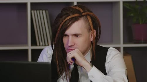 Young Man in Business Suit Working at Laptop in Home Office