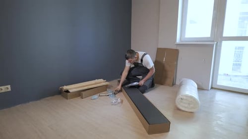 The Worker Looks at the Instructions for Assembling Furniture