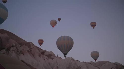 Hot Air Balloons Floating over Mountains at Sunrise
