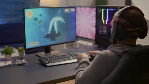 Young Adult Gamer Playing Computer Game with Controller