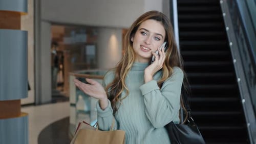 Stylish Woman Talks on Phone in Shopping Mall