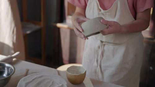 Adult Working and Molding Clay into a Bowl