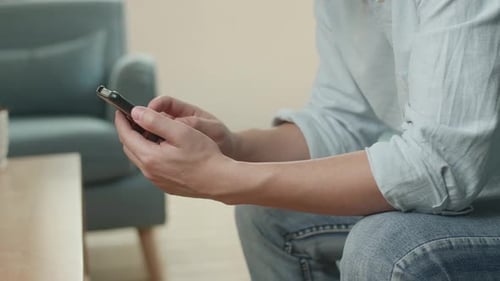 Person Using Smartphone in Bright Indoor Setting