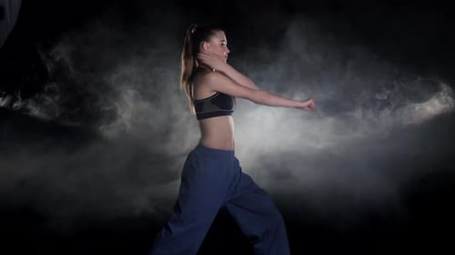 Woman Performing Martial Arts in Studio with Smoke