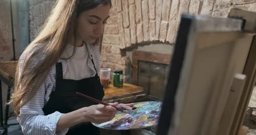 Artist Painting on Canvas in Studio