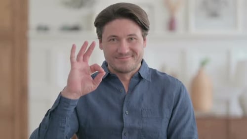 Smiling Man Gives Ok Sign Indoors