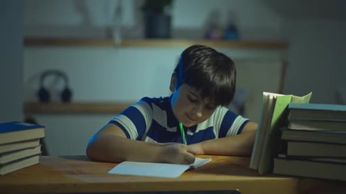 Boy Studying at Desk in Home at Night
