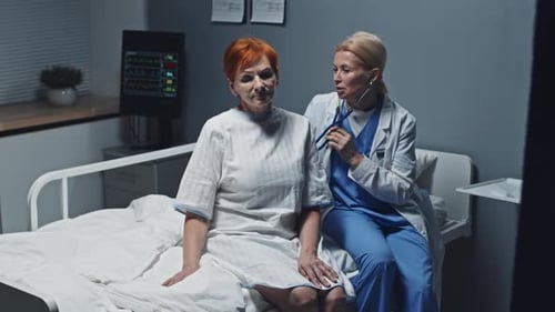 Doctor Examining Woman in Hospital Room With Stethoscope