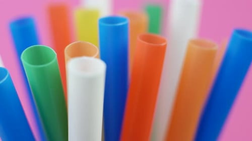 Colorful Plastic Straws Rotating on Pink Background