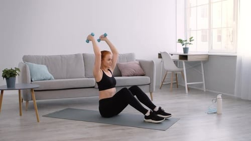 Woman Works Out at Home with Dumbbells