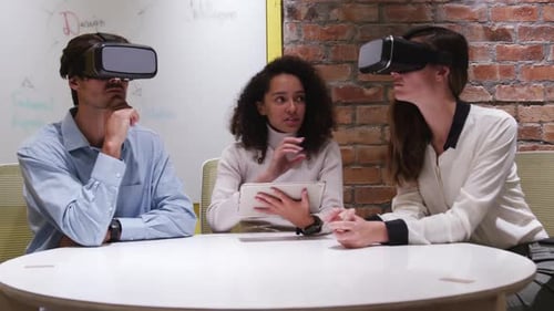 Creative businesspeople using virtual reality headset in modern office