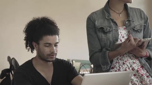 Young man working with colleague in office