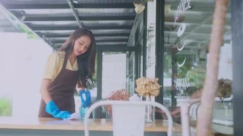 Close-up.Asian female worker clean the table is disinfected by sprinkling