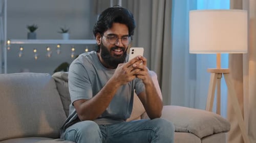 Man Using Smartphone While Relaxing on Couch