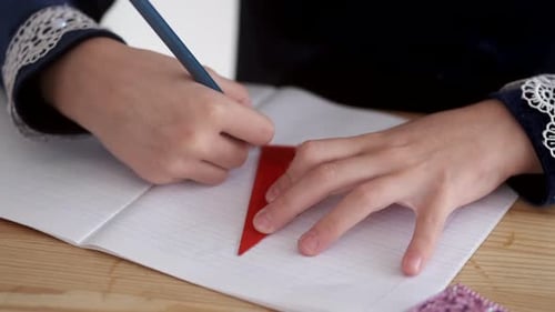 Cropped View of Kid's Hands Holding Pencil on Desk