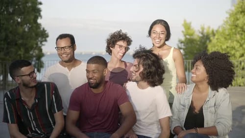 Glückliche Freunde unterhalten sich beim Sitzen auf einer Bank im Park