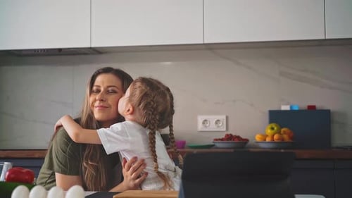 Mother and Daughter Sharing Affectionate Moment in Kitchen