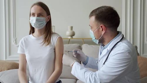 Doctor Giving Vaccine to Young Adult Woman