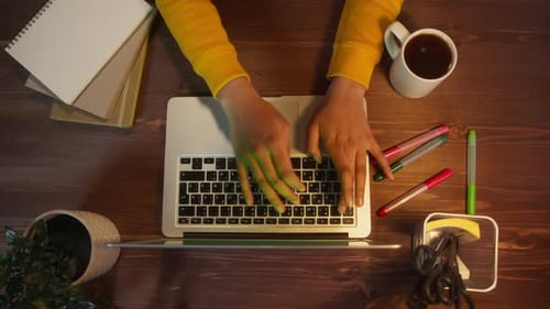Beautiful Black Woman Sitting at Her Desk Works on a Laptop with Green Chroma Key Mockup Screen