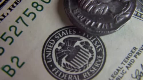 Ancient Coin Sitting on US Dollar Bill