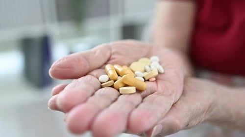 Hand Holding Pills Close Up