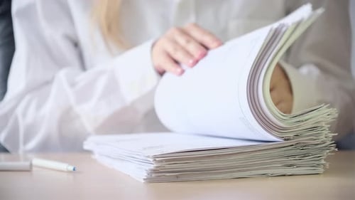Office worker in workplace signing many documents, contracts, agreements, papers