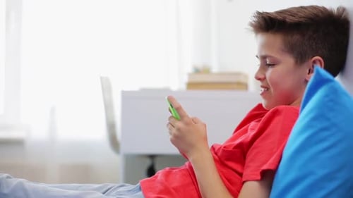 Boy Using Phone While Relaxing at Home