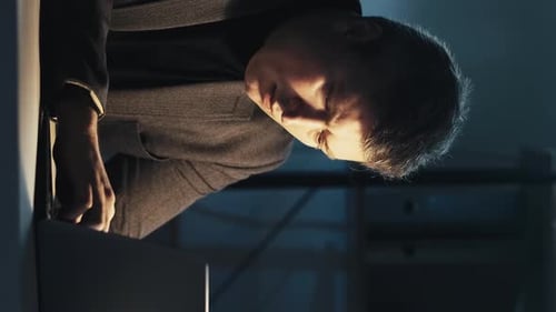 Man Working Late at Laptop in Dark Office