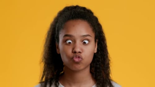 Teen Girl Making Silly Faces on Yellow Background