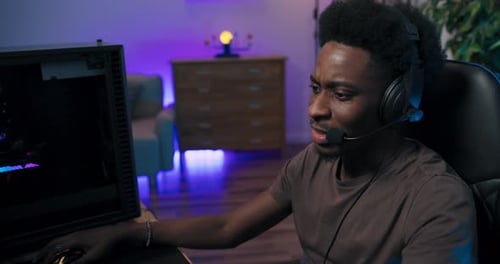 Focused Young Adult Gaming at Night