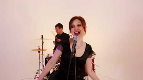 A Musical Band of Four People in Black Clothes Playing Song in the Studio - Filming a Dynamic Music