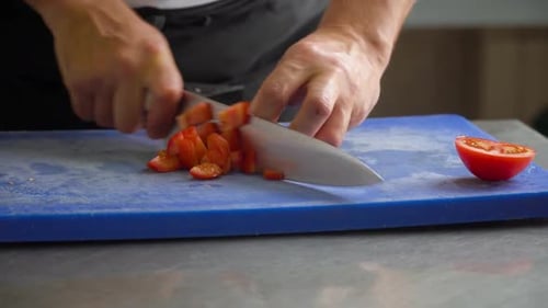 Close Up of a Chopping Tomato Chef on a Blue Board