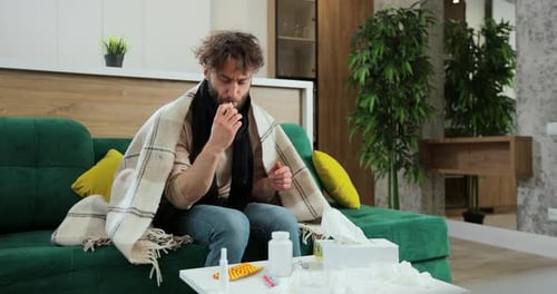 Man with Cold Taking Temperature at Home