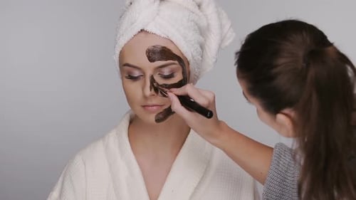 Woman Applies Beauty Mask to Face of Another