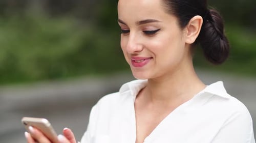 Smiling Woman Using Phone in City Close Up