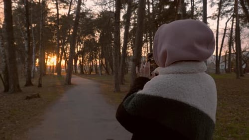 Young Adult Taking Sunset Photo in Park